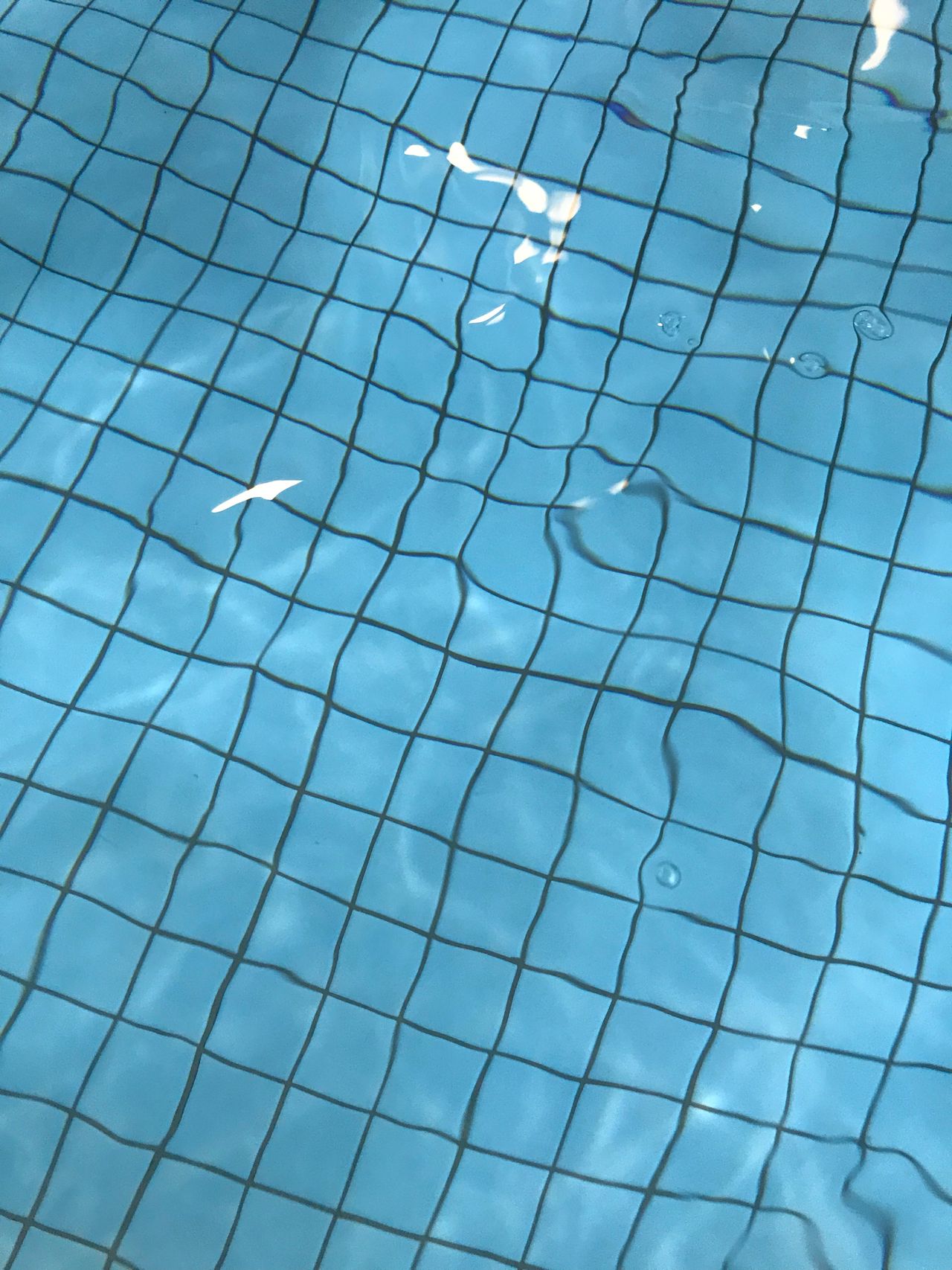 Pool floor seen through clear blue water
